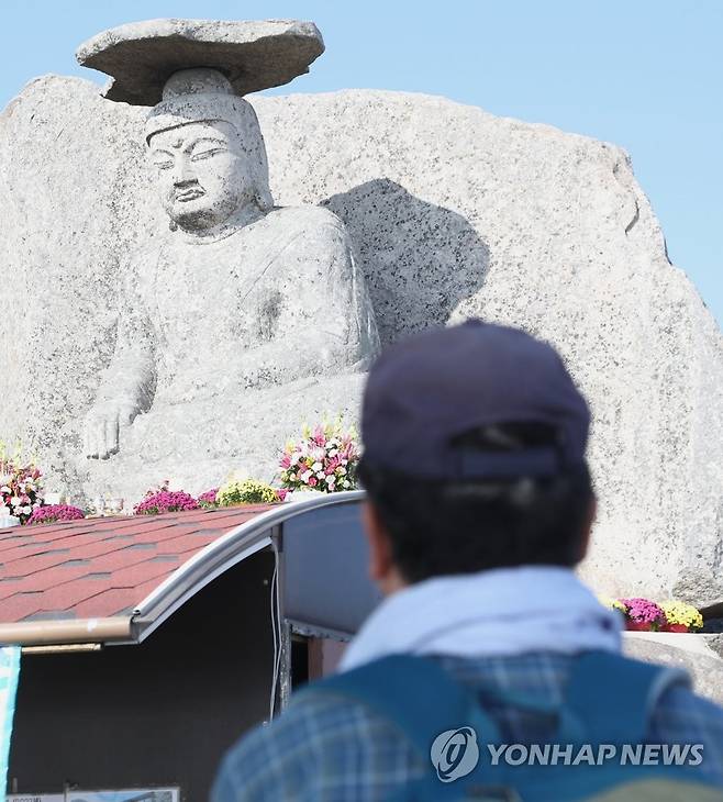 수능을 앞두고 (경산=연합뉴스) 황수빈 기자 = 수능을 일주일 앞둔 10일 오전 경북 경산시 와촌면 팔공산 갓바위에서 한 시민이 기도하고 있다.
    갓바위는 관봉석조여래좌상으로 6ｍ 규모의 불상 머리에 갓 모양의 넓은 돌이 얹어진 모습이다. 간절히 빌면 한가지 소원은 꼭 들어준다는 이야기가 전해져 해마다 수능을 앞두고 학부모들의 발길이 이어진다. 2022.11.10 hsb@yna.co.kr