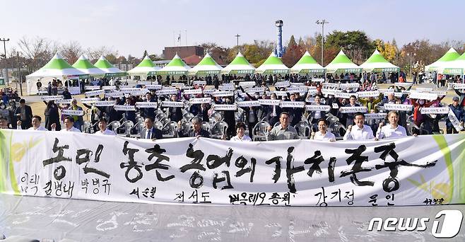 강기정 광주시장과 광주 5개 구청장, 농업인단체 등이 11일 오전 서구 상무시민공원에서 열린 제27회 농업인의 날 행사에 참석해 농민수당 지원 협약을 체결한 뒤 기념촬영을 하고 있다.(광주시 제공)2022.11.11/뉴스1 ⓒ News1