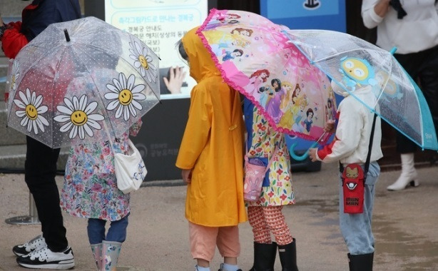 서울 경복궁에서 비가 내리자 아이들이 우산을 쓰고 이동하고 있는 모습. 뉴시스