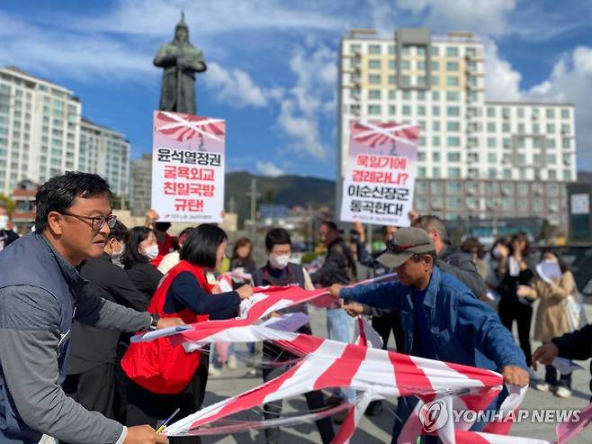 욱일기 찢기 (창원=연합뉴스) 지난달 29일 경남 창원시 진해구 북원로터리 이순신 장군 상 앞에서 열린 '친일 국방 규탄' 기자회견에서 참가자들이 욱일기를 찢고 있다.
    민주노총 경남본부 등 참석자들은 정부가 '일본 해상자위대 창설 70주년 관함식'에 해군 함정을 보내기로 한 데 대해 "참가를 철회하라"고 밝혔다. 2022.10.29 [민주노총 경남본부 제공. 재판매 및 DB 금지] image@yna.co.kr