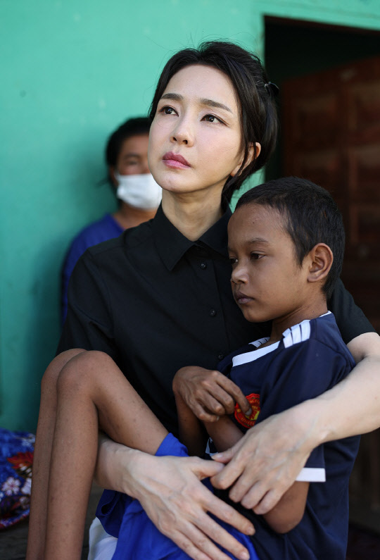 김건희 여사가 12일(현지시간) 캄보디아 프놈펜의 한 선천성 심장질환을 앓고 있는 환아의 집을 찾아 건강 상태를 살피고 있다.  김 여사는 지난 11일 헤브론 의료원을 방문했을 때 심장병 수술을 받은 아동들을 만나는 자리에 건강 상태가 좋지 않아 참석하지 못했던 이 환아의 집을 이날 방문했다.<대통령실 제공>