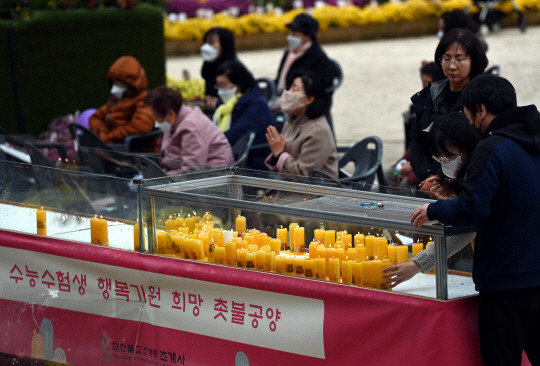 2023학년도 대학수학능력시험을 앞둔 13일 서울 종로구 조계사에 서 수험생 학부모들이 수능 고득점 기원 초에 불을 붙여놓고 있다.  박윤슬 기자