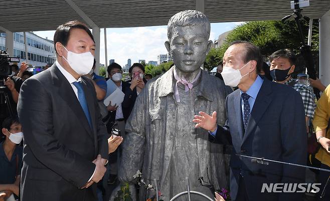 [서울=뉴시스] 국회사진기자단 = 윤석열 대통령(당시 국민의힘 대선 경선 후보)이 지난해 9월3일 장기표 경선 후보와 서울 종로구 청계천 전태일 열사 동상 앞에서 대화하고 있다. 2021.09.03. photo@newsis.com