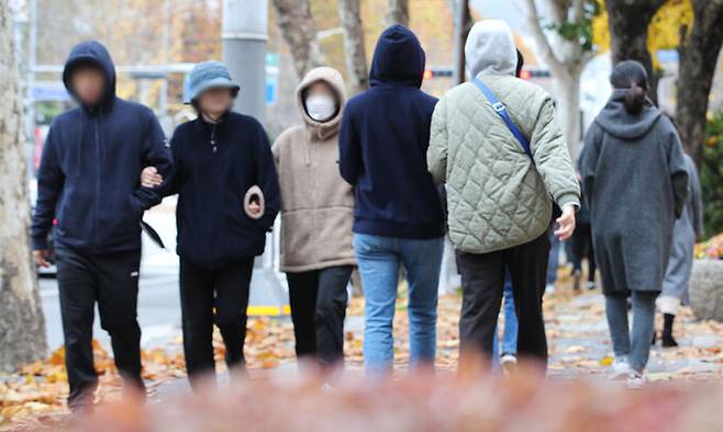 지난 12일 내린 비로 체감온도가 뚝 떨어진 13일 서울 강남구 거리에서 시민들이 모자를 쓰고 이동하고 있다. 뉴시스