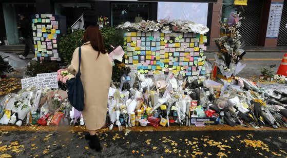 13일 서울 이태원역 1번 출구 앞 추모공간에서 시민들이 희생자를 애도하고 있다. [뉴스1]