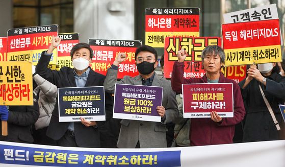 A group of people that invested in the German Heritage derivative-linked (DLS) securities products demand compensation in front of the Financial Supervisory Service office in western Seoul on Monday. [YONHAP]