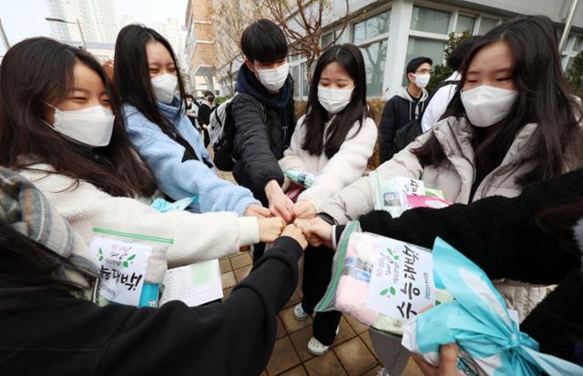 대학수학능력시험을 하루 앞둔 16일 오전 세종시 한 고등학교에서 수험표를 받은 수험생들이 학부모와 교직원들이 마련한 선물을 들고 파이팅하고 있다. 세종=연합뉴스