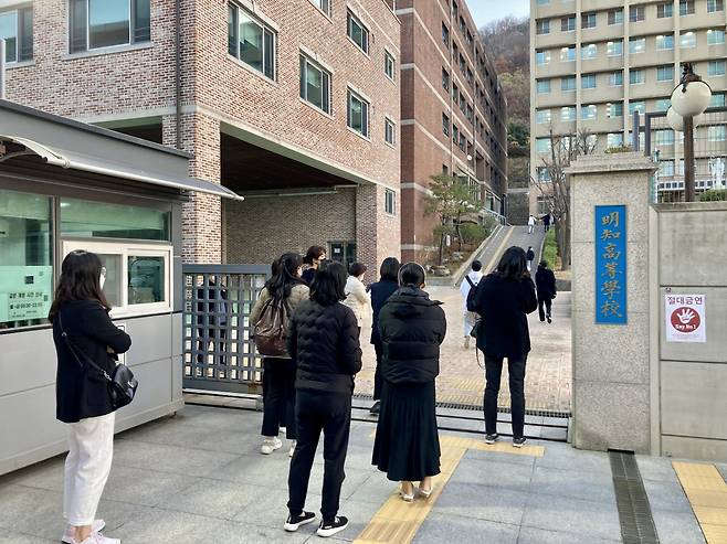 Parents watch as their children enter the testing site for the Suneung, Thursday. (Im Eun-byel / The Korea Herald)