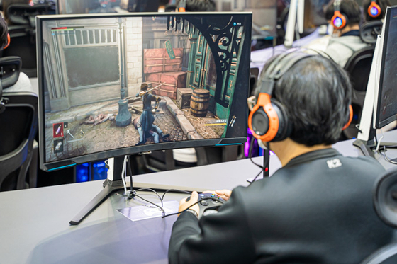 A visitor tries out Neowiz's upcoming roleplaying game Lies of P at the company's booth set up inside G-Star 2022 annual game festival held at Bexco, Busan, on Thursday. [NEOWIZ]