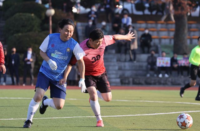 더불어민주당 김영진 의원(왼쪽)과 국민의힘 이용 의원(오른쪽)이 18일 여야 국회의원 축구대회에서 볼다툼을 벌이고 있다. 연합뉴스