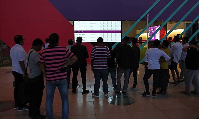 월드컵 입장권을 사려는 시민들이 지난 17일 카타르 도하 주 매표소 들머리 전광판 앞을 떠나지 못하고 있다. 도하/김혜윤 기자