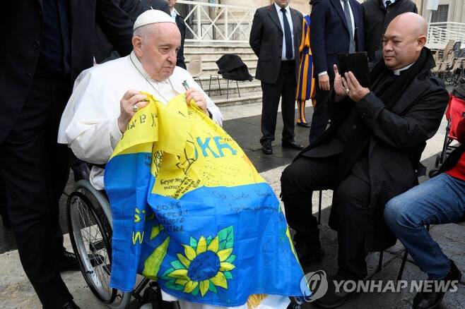 우크라이나 국기 든 프란치스코 교황 (바티칸 로이터=연합뉴스) 프란치스코 교황이 16일(현지시간) 바티칸에서 열린 수요 일반 알현에서 우크라이나 국기를 들고 있다. 2022.11.19 photo@yna.co.kr