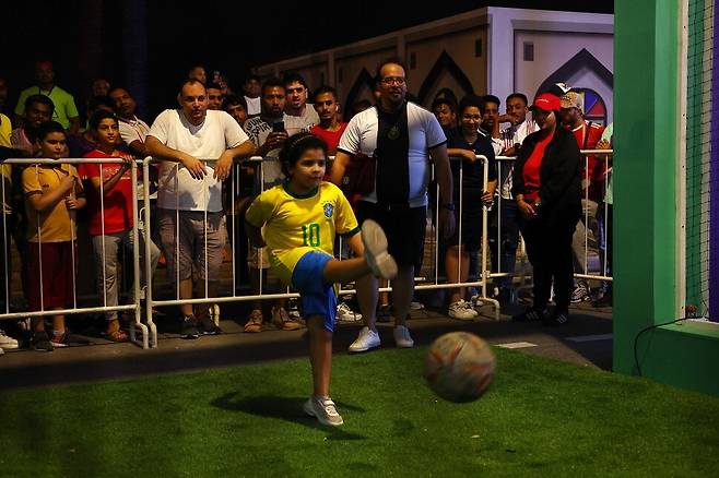 카타르 도하 코르니쉬 해변가에 마련된 월드컵 기념 부스에서 축구 게임을 하는 한 어린이를 시민들이 지켜보고 있다. 도하/김혜윤 기자