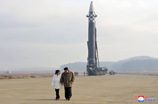 김정은 북한 국무위원장이 지난 18일 대륙간탄도미사일(ICBM) 화성-17형 앞에서 딸과 함께 걸어가고 있다. 조선중앙통신 연합뉴스