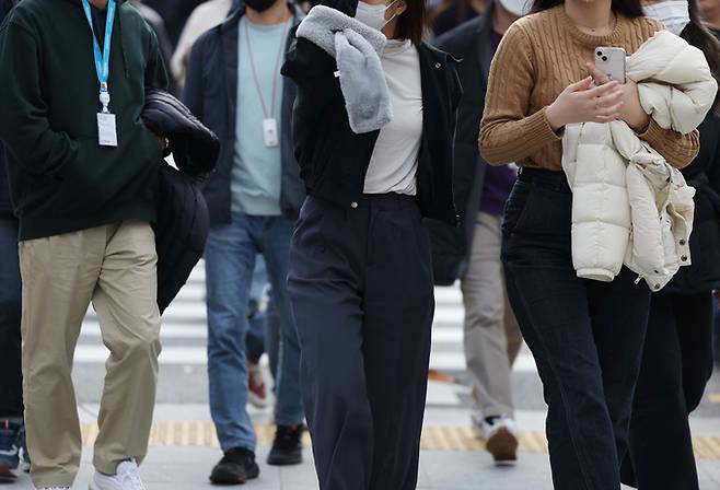 큰 추위 없는 늦가을 날씨가 이어지고 있는 21일 오후 겉옷을 손에 든 시민들이 광화문네거리를 지나고 있다.    연합뉴스