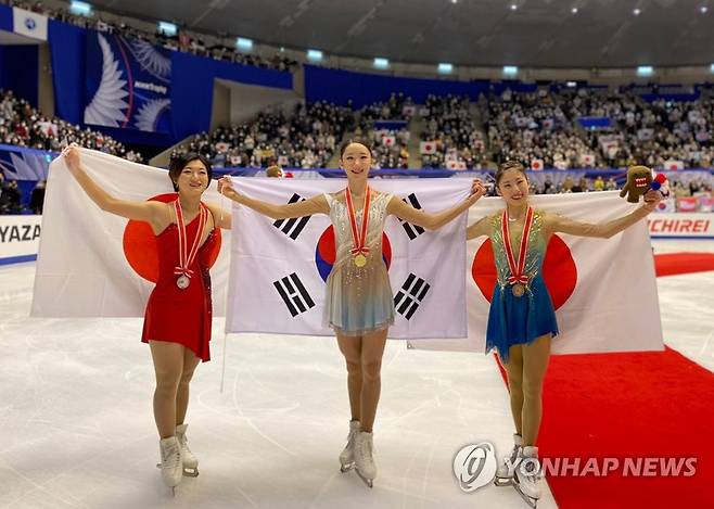 일장기 사이에 태극기 (서울=연합뉴스) '피겨장군' 김예림이 19일 일본 홋카이도현 삿포로 마코마나이 아이스 아레나에서 열린 2022-2023 국제빙상경기연맹(ISU) 시니어 그랑프리 5차 대회 NHK 트로피 프리스케이팅에서 금메달을 차지한 뒤 포즈를 취하고 있다.
    왼쪽은 은메달을 차지한 일본의 사카모토 가오리, 오른쪽은 동메달리스트인 일본의 스미요시 리온이다. 2022.11.19 [올댓스포츠 제공. 재배포 및 DB 금지] photo@yna.co.kr