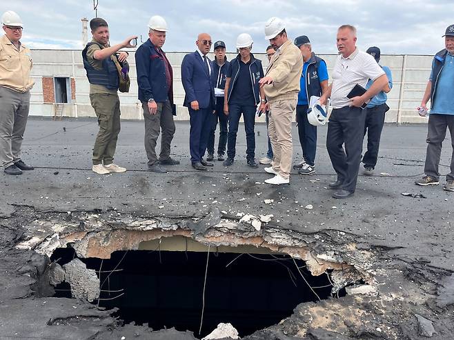 (에네르호다르 AFP=연합뉴스) 국제원자력기구(IAEA)의 라파엘 그로시(가운데) 사무총장과 사찰단이 지난 9월 1일(현지시간) 우크라이나 자포리자 원자력발전소를 방문해 포격으로 손상된 건물 지붕을 살펴보고 있다. IAEA는 지난 6일 잇따른 포격으로 안전에 대한 우려가 커진 자포리자 원전 사찰 결과를 발표하고, 원전 주변에 보호구역을 설정할 것을 촉구했다.