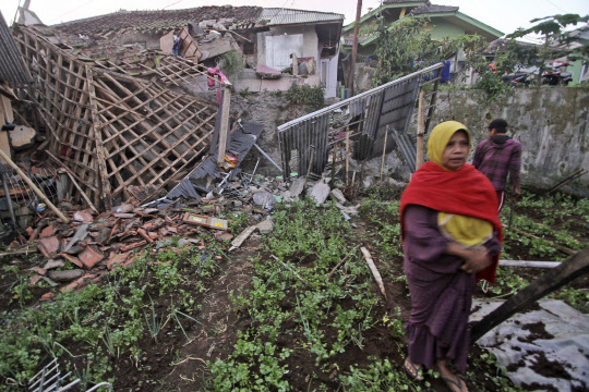 인도네시아 지진(치안주르[인도네시아] AP=연합뉴스) 21일(현지시간) 인도네시아 서자바주 치안주르에서 발생한 지진으로 파손된 집 앞을 한 여성이 지나가고 있다. 인도네시아 당국은 이번 지진으로 62명이 사망했다고 밝혔다. [치안주르(인도네시아) AP=연합뉴스]