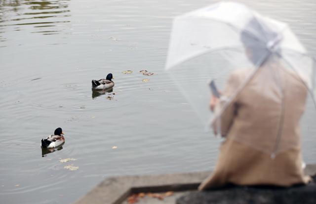 빗방울이 떨어진 22일 오후 광주 북구 전남대학교 교정에서 우산을 쓴 시민이 연못을 바라보고 있다. 올해 광주·전남 지역은 관측 이래 가장 적은 비가 내리며 심각한 가뭄 위기에 처했다. 광주=연합뉴스
