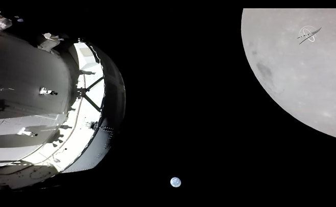 지난 21일(미국시간) 오리온 우주선의 동체에 달린 카메라에 지구(사진 가운데 아래 파란색 원)와 달(사진 오른쪽 회색 원)이 촬영됐다. 미국 항공우주국(NASA) 제공