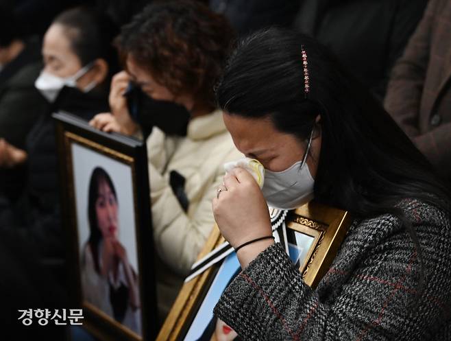 이태원 참사 희생자의 유족들이 22일 서울 서초구 민주사회를위한변호사모임에서 열린 기자회견에서 자녀의 영정사진을 품에 안고 눈물을 흘리고 있다. 문재원 기자