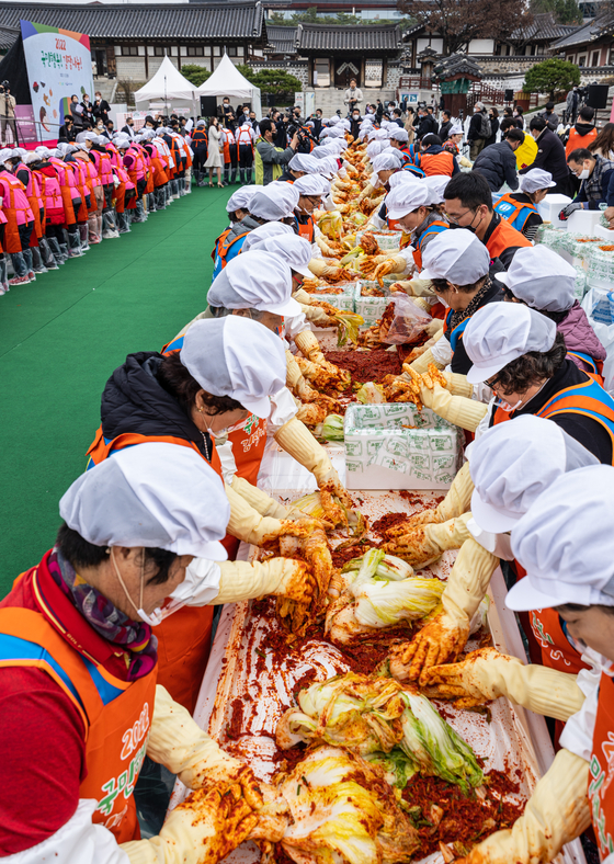 Volunteers make kimchi for socially vulnerable groups at the Namsangol Hanok Village in central Seoul on Tuesday. Hosted by Nonghyup, a total of 25,000 heads of kimchi including those made at the event will be delivered to various social welfare centers. [YONHAP]