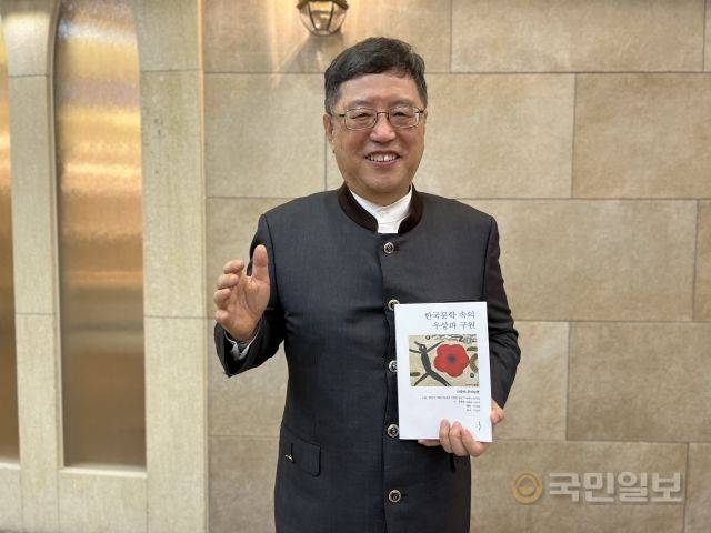 안준배 목사가 저서를 들어보이고 있다.