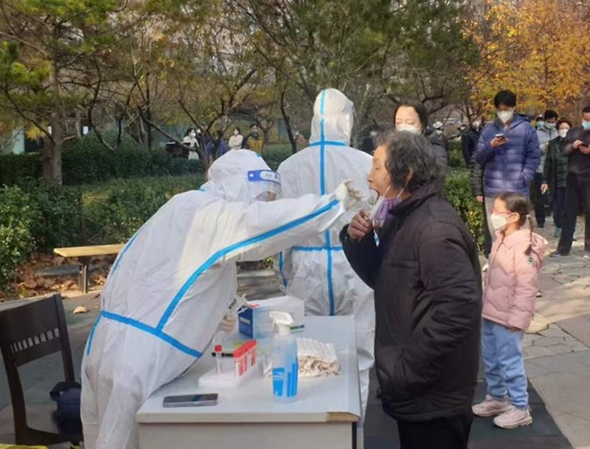 23일 중국 베이징의 봉쇄된 아파트에서 경비원이 주민을 대상으로 PCR 검사를 하고 있다.ⓒ연합뉴스