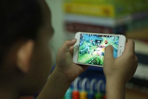 중국의 한 청소년이 휴대폰으로 온라인 게임을 즐기고 있다. 차이신 기사 화면 캡처