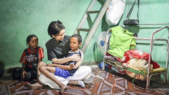 윤석열 대통령 부인 김건희 여사가 12일 캄보디아 프놈펜에서 선천성 심장질환을 앓고 있는 14세 아동의 집을 찾아 아이를 안고 있는 모습. 사진 대통령실