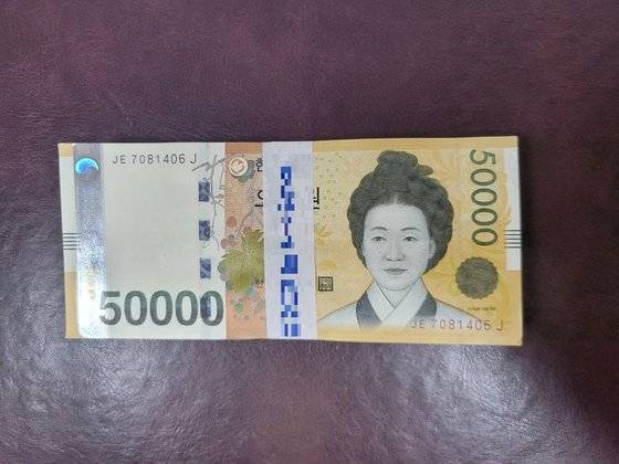 5만원권 100장이 띠지로 묶여 있다. 대개 시중은행에서는 해당 은행 로고를 찍은 띠지를 사용한다. 최현주 기자