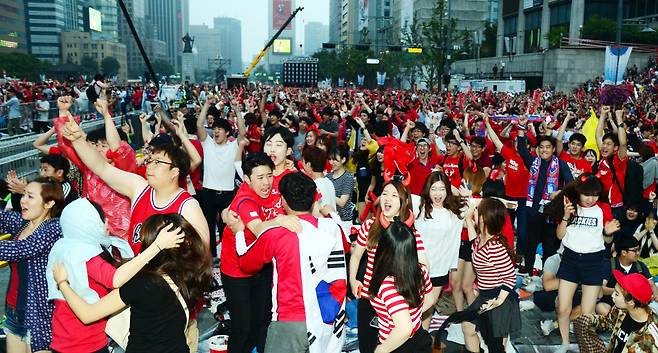 South Korean fans cheer for their national soccer team at the street cheering event for the 2014 FIFA World Cup at Gwanghwamun Plaza in Seoul in this June 23, 2014 file photo. (Korea Herald)
