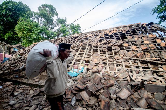 인도네시아 서자바주 치안주르의 한 주민이 22일(현지시간) 이 지역에서 전날 발생한 규모 5.6의 강진으로 파손된 집을 지나가고 있다. 신화/연합