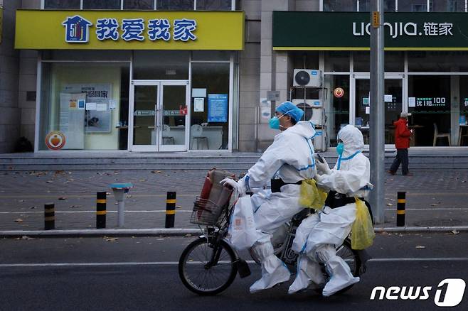 (베이징 로이터=뉴스1) 최종일 기자 = 동절기에 접어들면서 중국에서 6개월 만에 처음으로 사망자가 발생하는 등 코로나19가 창궐하고 있는 가운데 방역 요원들이 방역복을 입은 채 전기 자전거를 타고 이동하고 있다.   ⓒ 로이터=뉴스1  Copyright (C) 뉴스1. All rights reserved. 무단 전재 및 재배포 금지.
