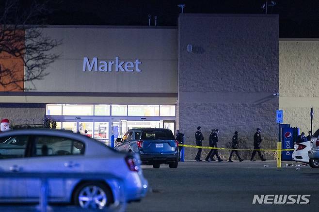 [AP/뉴시스] 미 버지니아주 체사피크시 월마트에서 총격으로 여러 명이 사망한 뒤 경찰이 23일 새벽 현장에서 나오고 있다