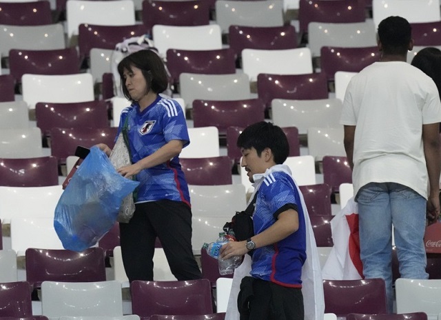 23일(한국시간) 카타르 알라이얀의 할리파 인터내셔널 스타디움에서 열린 독일과의 카타르 월드컵 조별리그 E조 1차전에서 승리를 거둔 일본 팬들이 경기 후 경기장을 청소하는 모습. AP연합뉴스