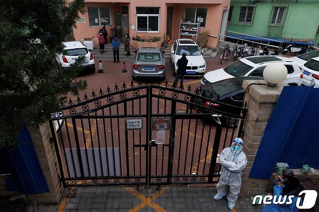 18일 중국 베이징에서 방진복을 입은 방역 요원이 코로나19 확산으로 봉쇄된 주거지를 감시하고 있다. ⓒ 로이터=뉴스1 ⓒ News1 임세원 기자