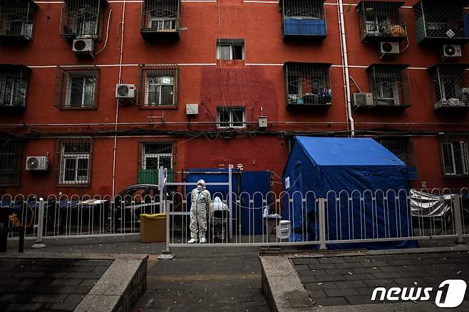 24일 코로나 봉쇄령이 내려진 베이징에서 방호복을 입은 의료 종사자가 주거 지역 입구를 경비하고 있다. ⓒ AFP=뉴스1 ⓒ News1 우동명 기자