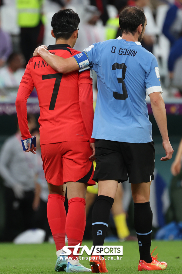 24일(현지시간) 카타르 알라이얀 에듀케이션 시티 스타디움에서 열린 2022 카타르 월드컵 H조 1차전 대한민국과 우루과이의 경기, 전반전이 끝나고 양팀 주장 손흥민과 디에고 고딘이 어깨동무하고 있다. 사진｜뉴시스