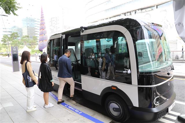 시민들이 24일 서울 중구 청계광장에서 전기 자율주행 버스에 탑승하고 있다. 25일부터는 전용 앱으로 예약한 시민 누구나 무료로 탑승할 수 있다. 서울시 제공
