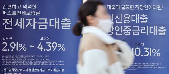 16일 서울 시내 한 은행 대출 금리 홍보물 앞을 시민이 지나고 있다. 연합뉴스