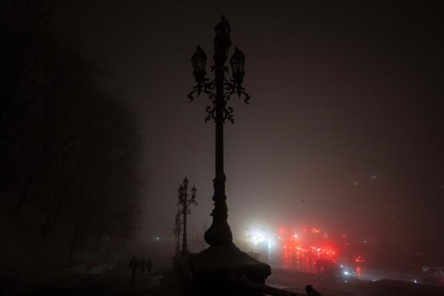 24일 우크라이나 키이우 일대에 대규모 정전이 발생하자 시민들이 불이 꺼진 시내를 차량 라이트에 의지한 채 걷고 있다. 키이우=AP 연합뉴스