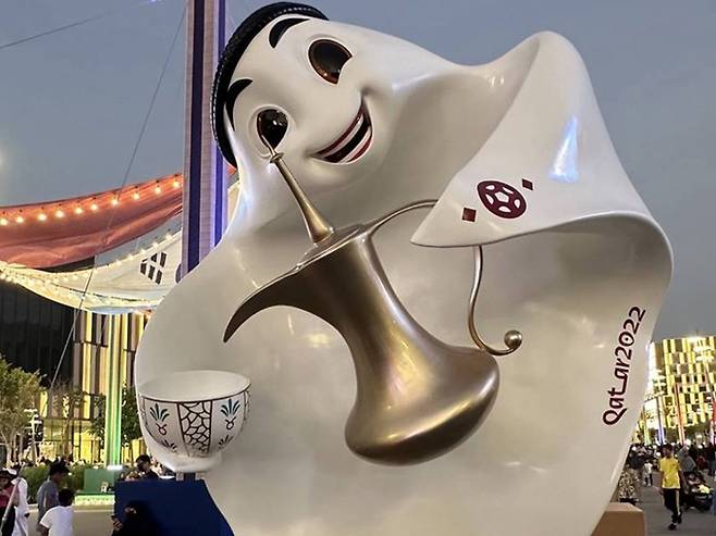 FIFA 월드컵이 열리는 카타르 도하의 거리에 설치된 대형 월드컵 마스코트 ‘라이브(La eeb)’. 왼손으로 커피가 든 ‘달라’를 ‘핀잔’에 담는 모습이다.