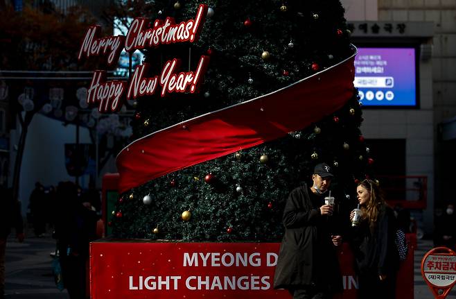 크리스마스를 한달 여 앞둔 지난 18일 오후 서울 중구 명동거리에 설치된 크리스마스 트리앞에서 여행객들이 즐거운 시간을 보내고 있다./뉴시스