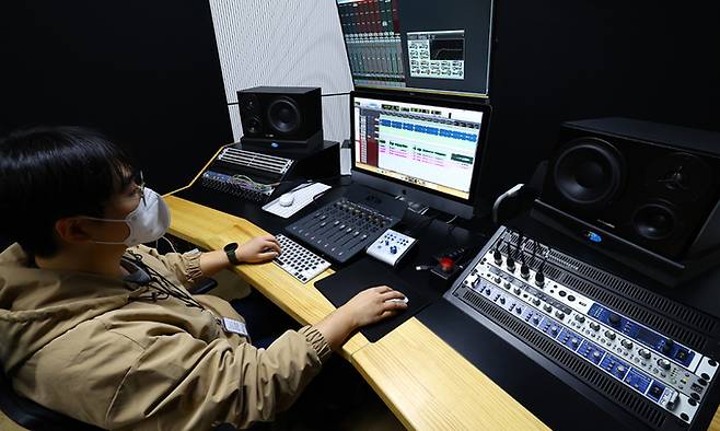김민우 대리가 녹음 스튜디오에서 아마추어 밴드의 오디오 후보정 작업을 하고 있다.