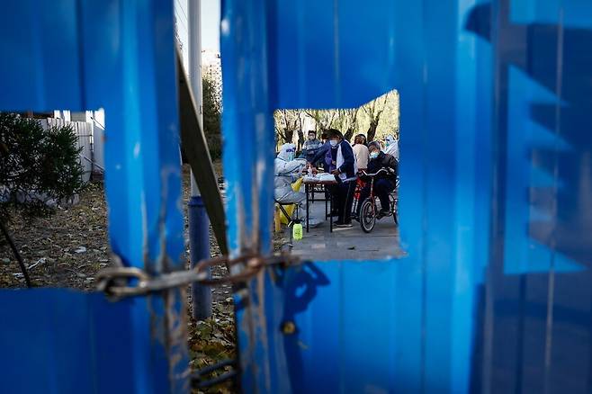 26일 중국 베이징의 한 주택가에서 주민들이 코로나19 검사를 받고 있다. 베이징/EPA 연합뉴스