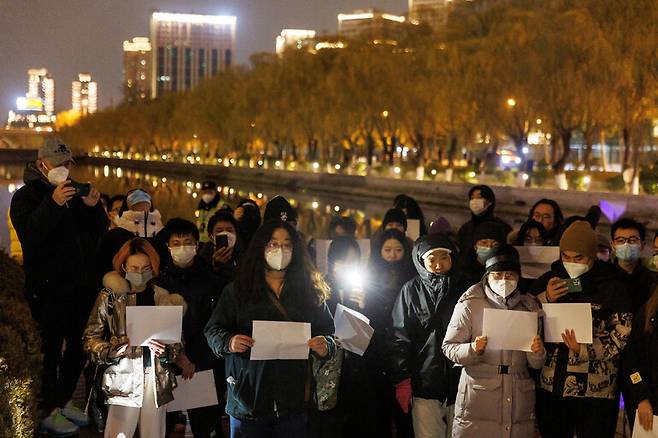27일 중국 베이징 차오양구 량마허에서 베이징 시민들이 A4 용지를 들고 과잉 방역에 대한 반대 시위를 하고 있다. 베이징/로이터 연합뉴스