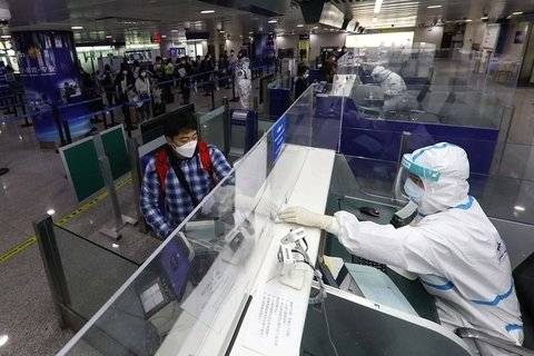 중국 공항에 도착한 외국인이 검역 요원에게 입국 수속을 하고 있다. [사진=차이신]