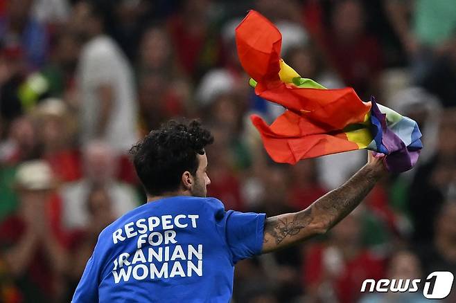 29일(한국시간) 열린 2022 카타르 월드컵 포르투갈과 우루과이 경기 도중 한 남성이 그라운드에 난입해 질주하고 있다. ⓒ AFP=뉴스1