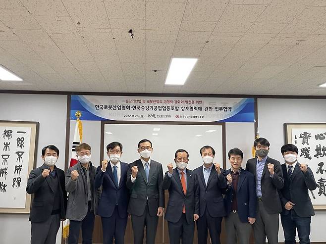 한국로봇산업협회 강철호 회장(왼쪽 네번째)과 한국승강기공업협동조합 최강진 이사장(왼쪽 다섯번째)이 지난 28일 한국승강기공업협동조합 회의실에서 '로봇산업 및 승강기산업의 경쟁력 강화와 발전을 위한 업무협약'을 체결한 뒤 기념촬영을 하고 있다. 왼쪽부터 트위니 김학창 이사, LG전자 김민철 담당, 한국로봇산업협회 조영훈 부회장, 한국로봇산업협회 강철호 회장, 한국승강기공업협동조합 최강진 이사장, 한국승강기공업협동조합 김윤용 전무, 한국승강기공업협동조합 김화진 전무, 현대로보틱스 안성환 상무, 한국로봇산업협회 이경준 본부장. 로봇산업협회 제공